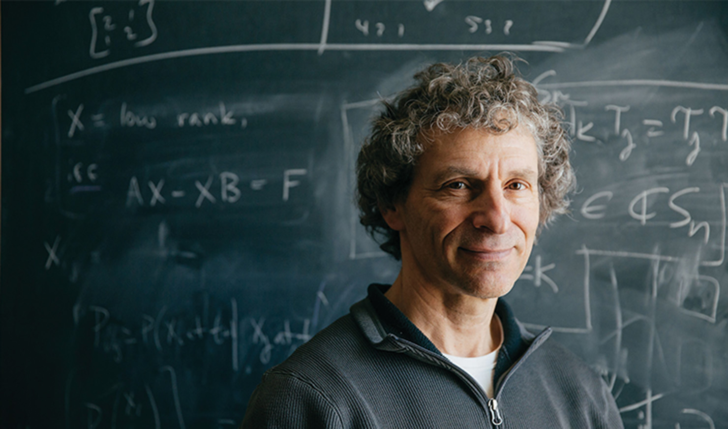 Man in front of blackboard of equations