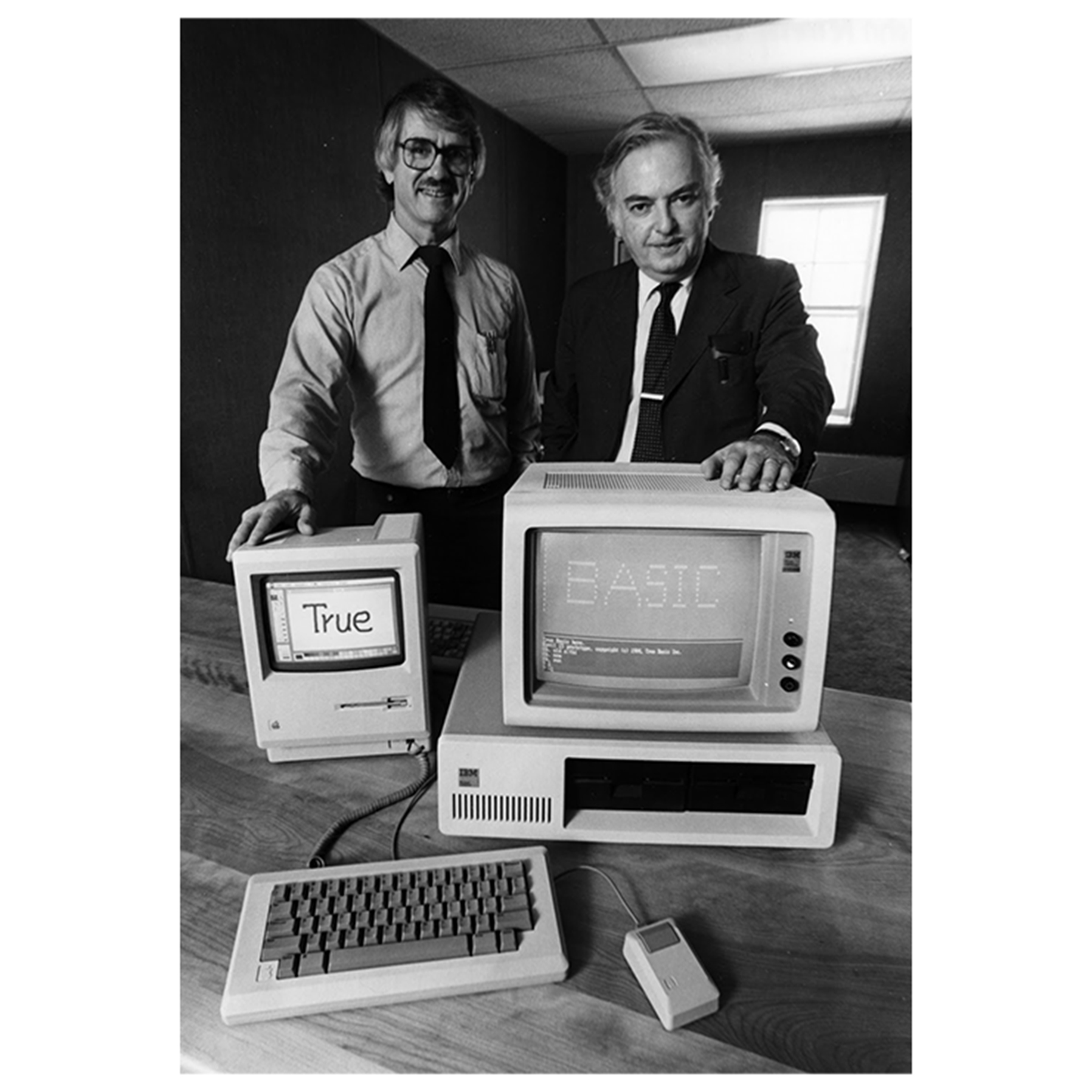 Men standing in front of computers