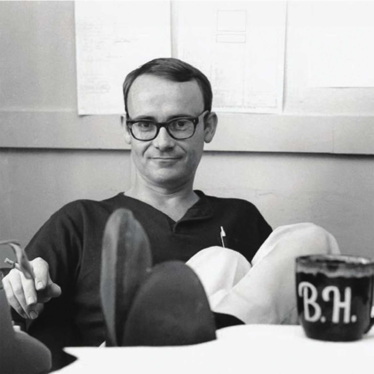 Man with feet on desk, smoking cigarette