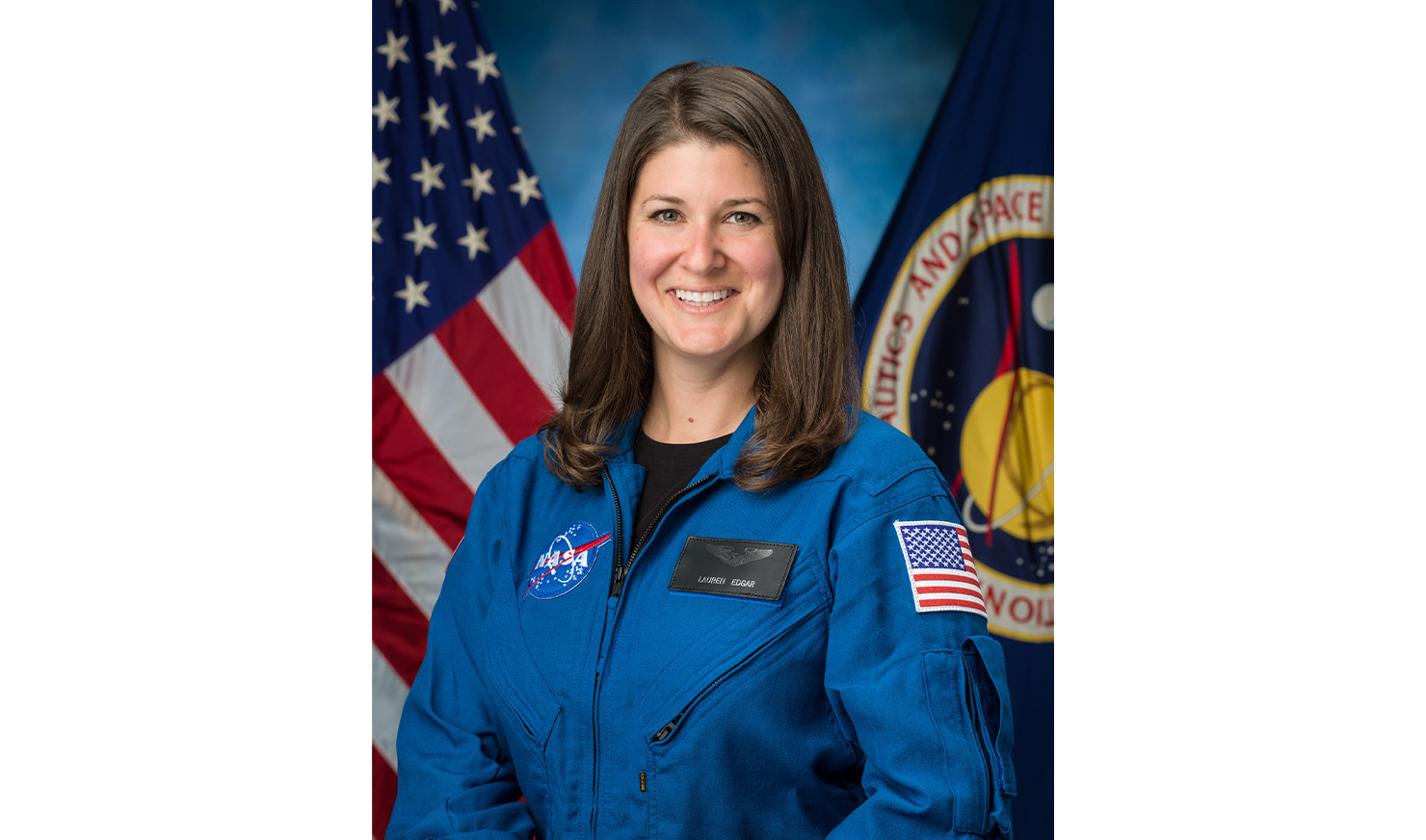 Woman posing in jumpsuit in front of flags