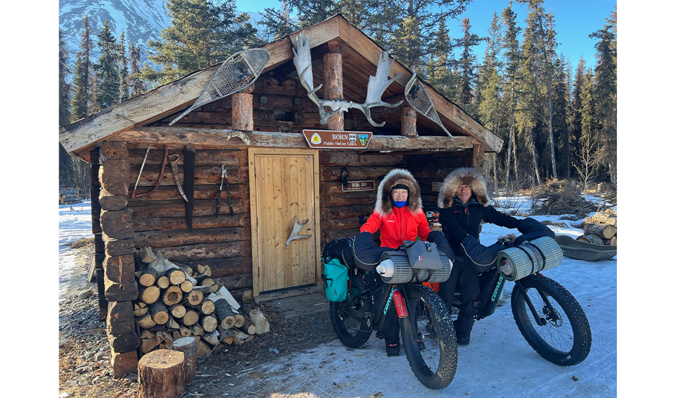 Snow bikers in front of cabin
