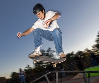 Skateboarder in the air, doing a trick off a rail