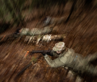 Cadets on ground in woods, holding guns