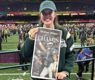 Woman holding up newspaper for Super Bowl champs