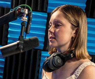 Woman sitting in front of microphone in studio