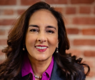 Headshot of woman in front of brick wall