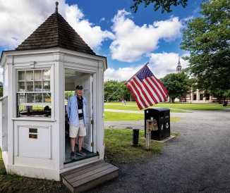 Man standing inside info booth on campus