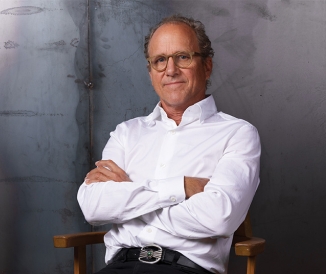 Man crossing arms while sitting in a studio