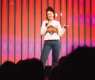 Woman holding microphone on stage in front of crowd