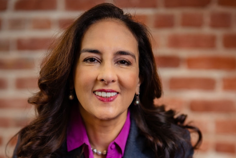 Headshot of woman in front of brick wall