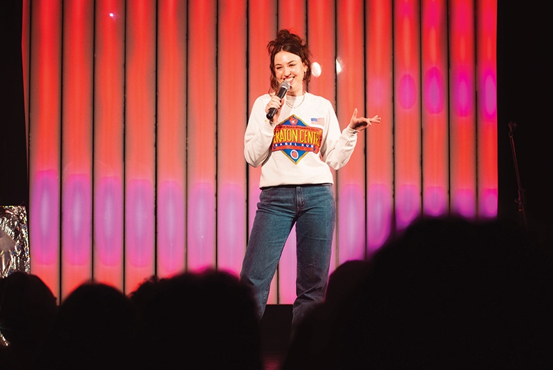 Woman holding microphone on stage in front of crowd