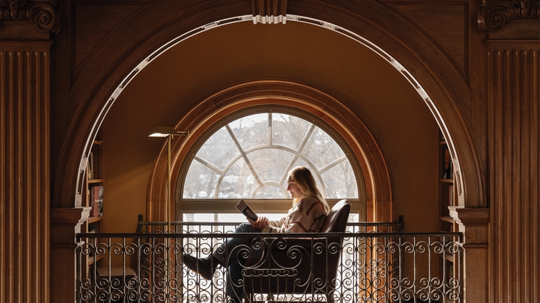 Woman reading book in library
