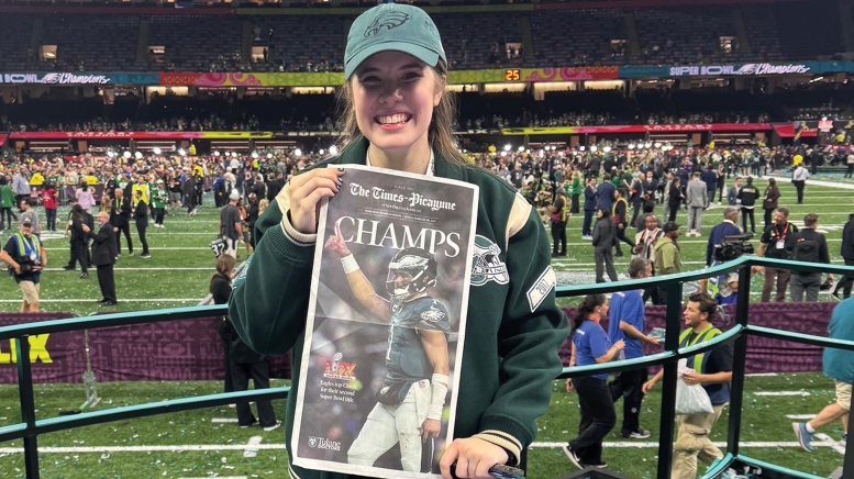 Woman holding up newspaper with Super Bowl champs