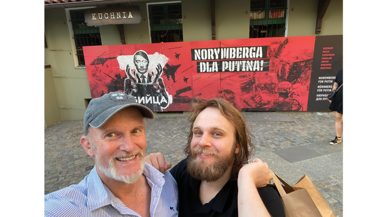 Two men in front of sign