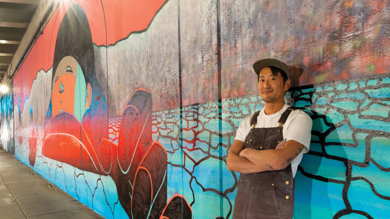 Man standing in front of mural