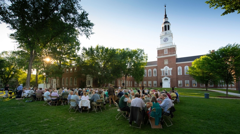 People sitting at tables in front of library