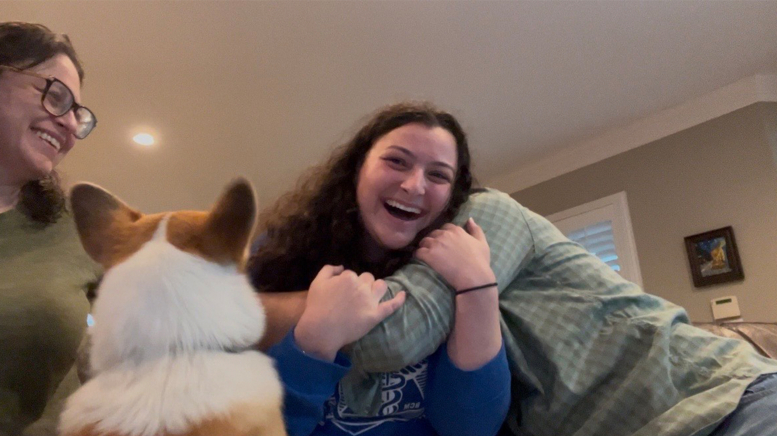 Daughter hugging parents with dog