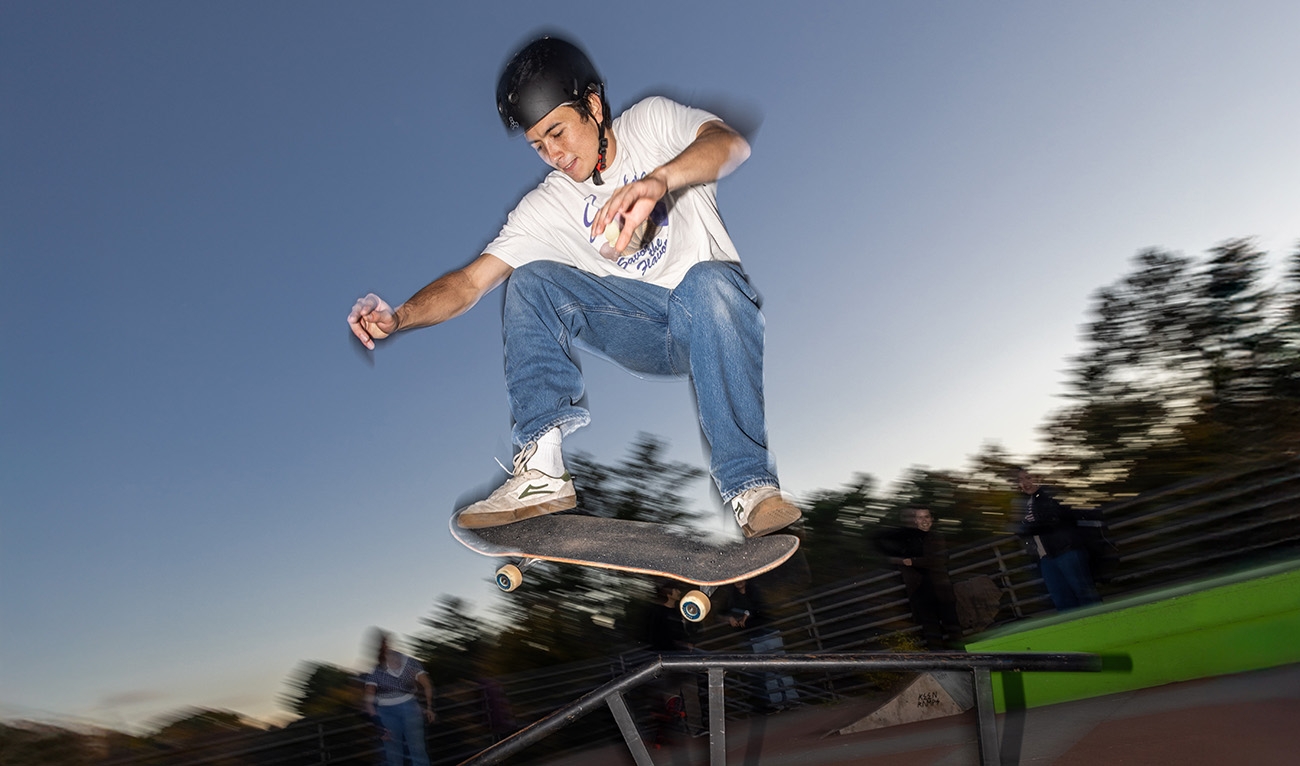 Skateboarder in the air, doing a trick off a rail