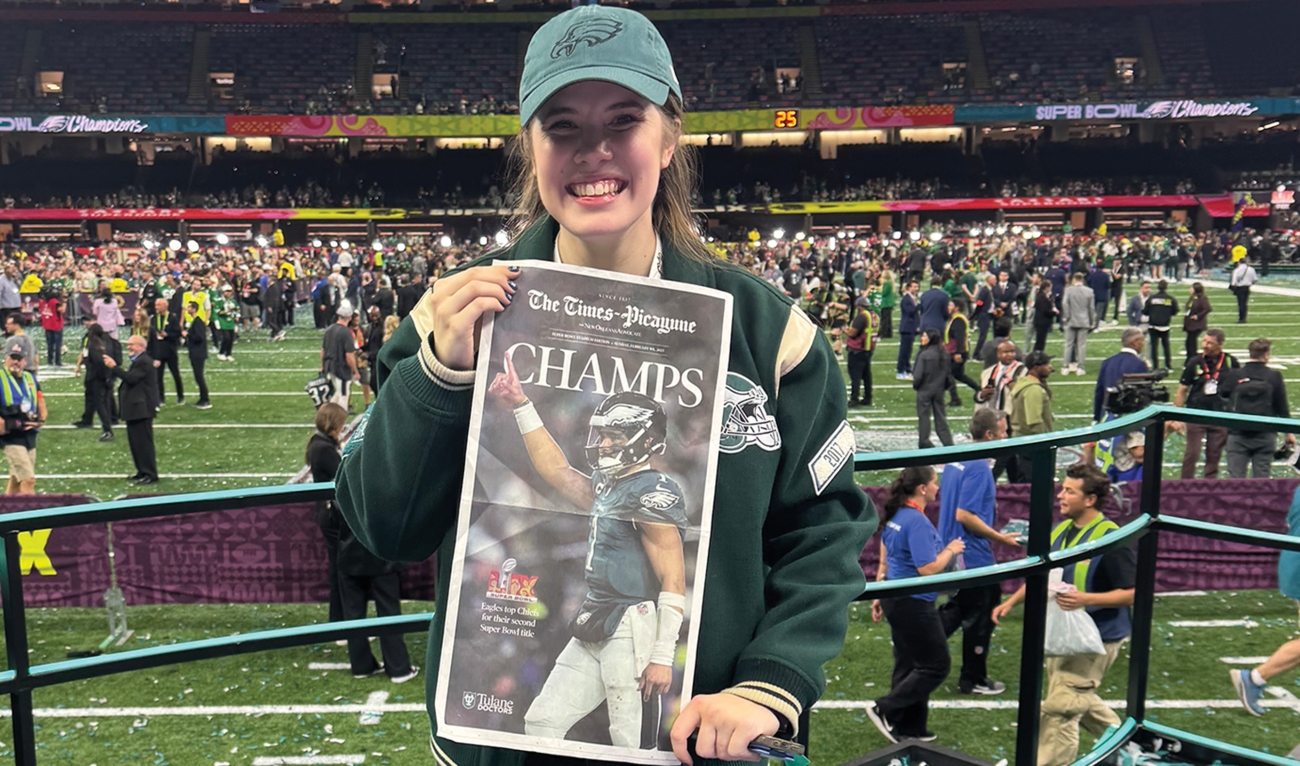 Woman holding up newspaper for Super Bowl champs