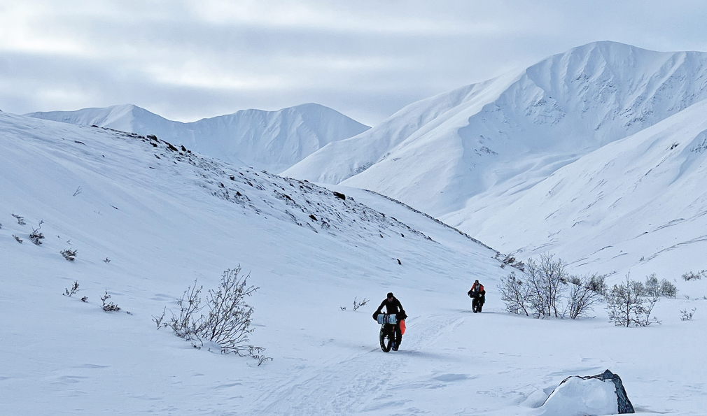Two people biking in snow