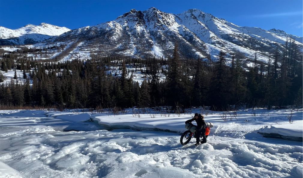 Person walking bike in snow