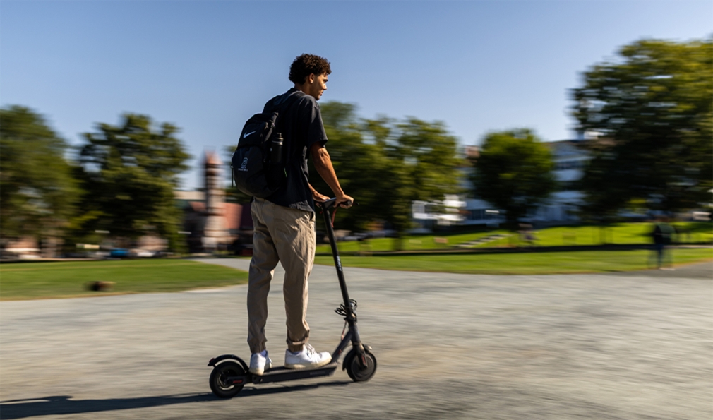 Man on e-scooter on campus