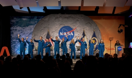 NASA astronaut candidates in jumpsuits waving