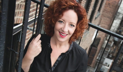 Headshot of woman posing on fire escape in city