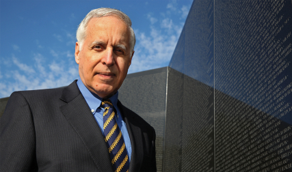 Man in front of memorial wall