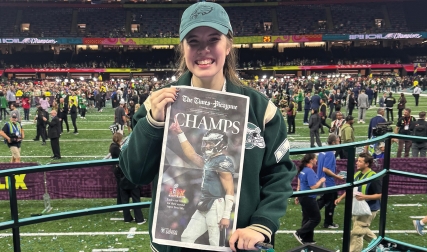 Woman holding up newspaper with Super Bowl champs