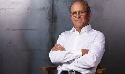 Man crossing arms while sitting in a studio