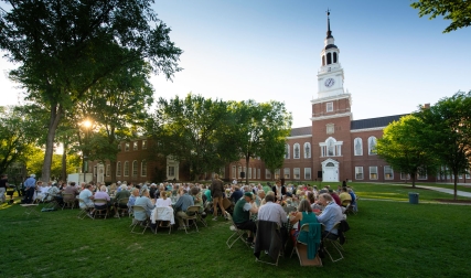 People sitting at tables in front of library