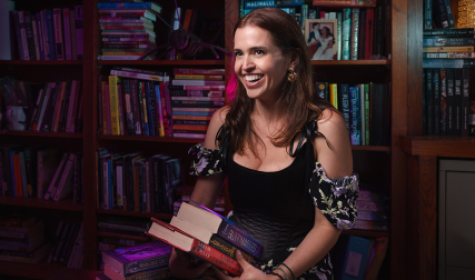Women holding stack of fantasy books