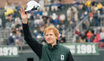 Man waving hat in air
