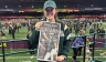 Woman holding up newspaper with Super Bowl champs