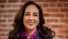 Headshot of woman in front of brick wall