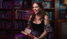 Women holding stack of fantasy books